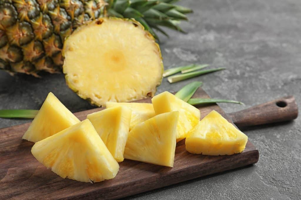 wooden board with fresh pineapple chunks