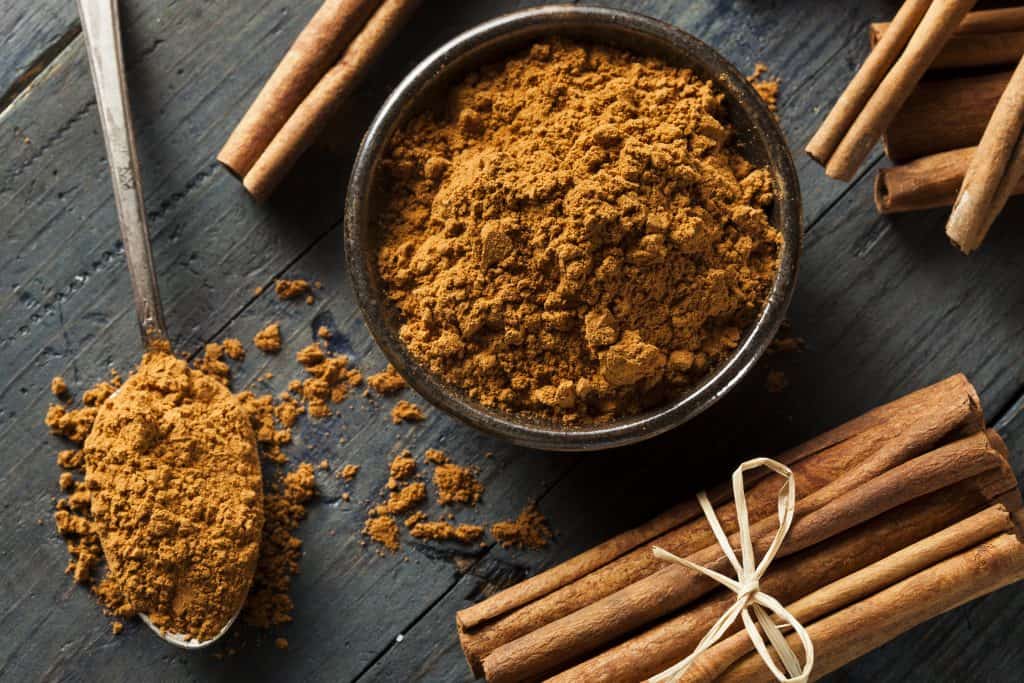 Organic Raw Brown Cinnamon on a Wooden Background