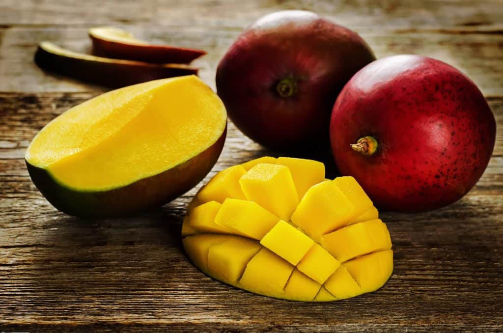 mango on a dark wood background. selective focus on the mangos slices