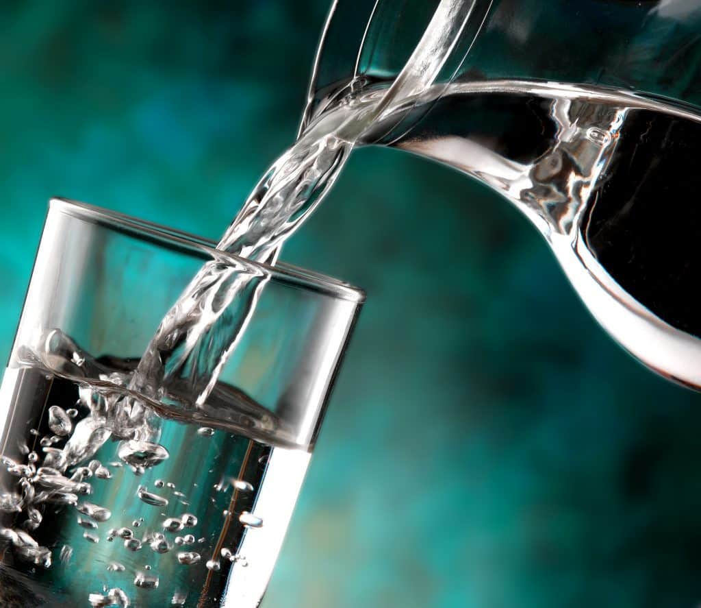 water being poured from pitcher into glass