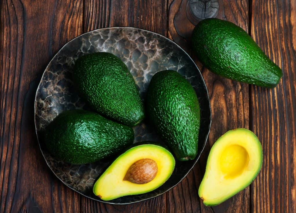 fresh green avocado on a wooden table