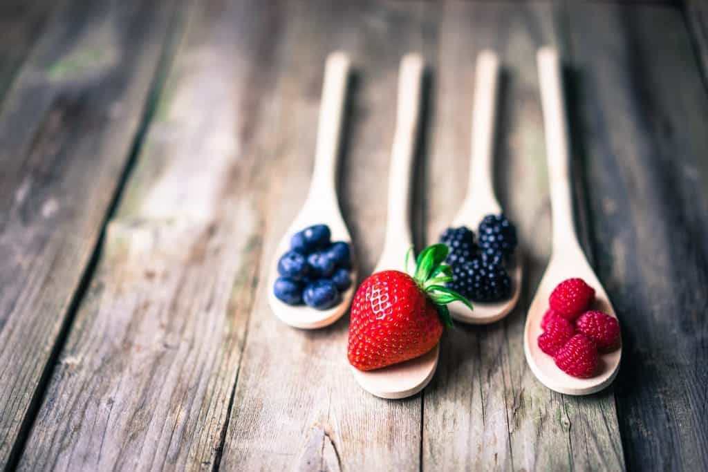 various berries on wooden spoons