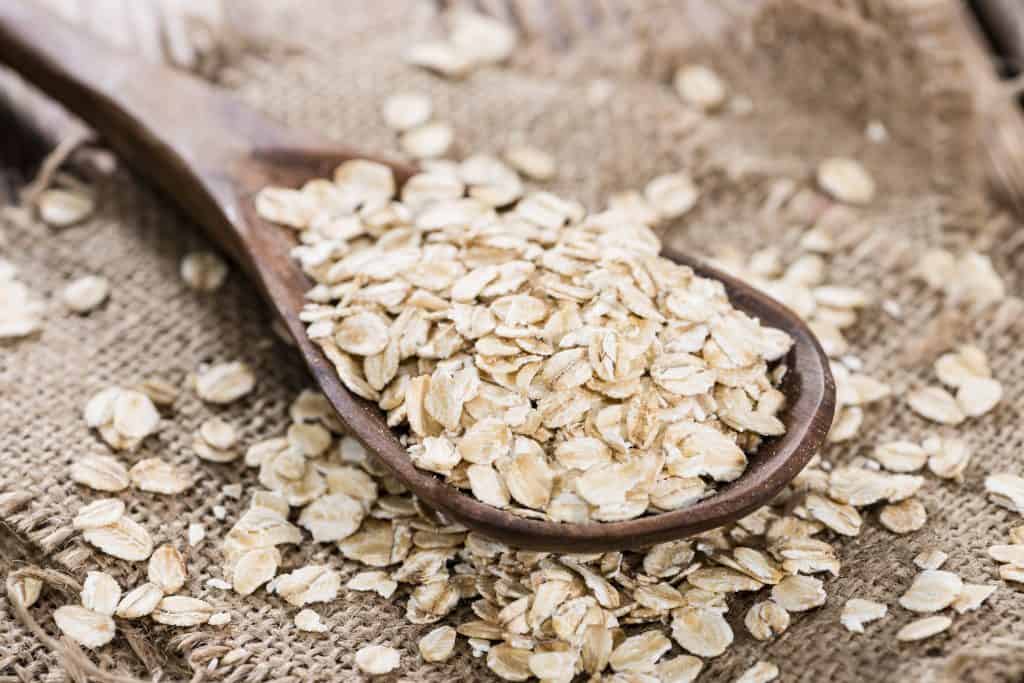 close up of oats in a wooden spoon