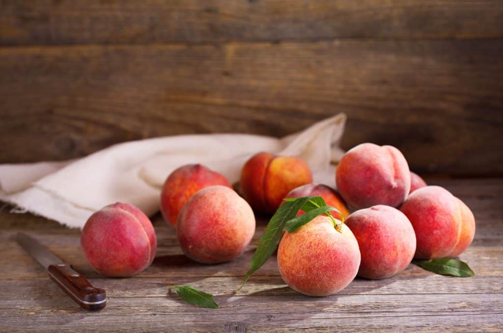 whole peaches on wooden background