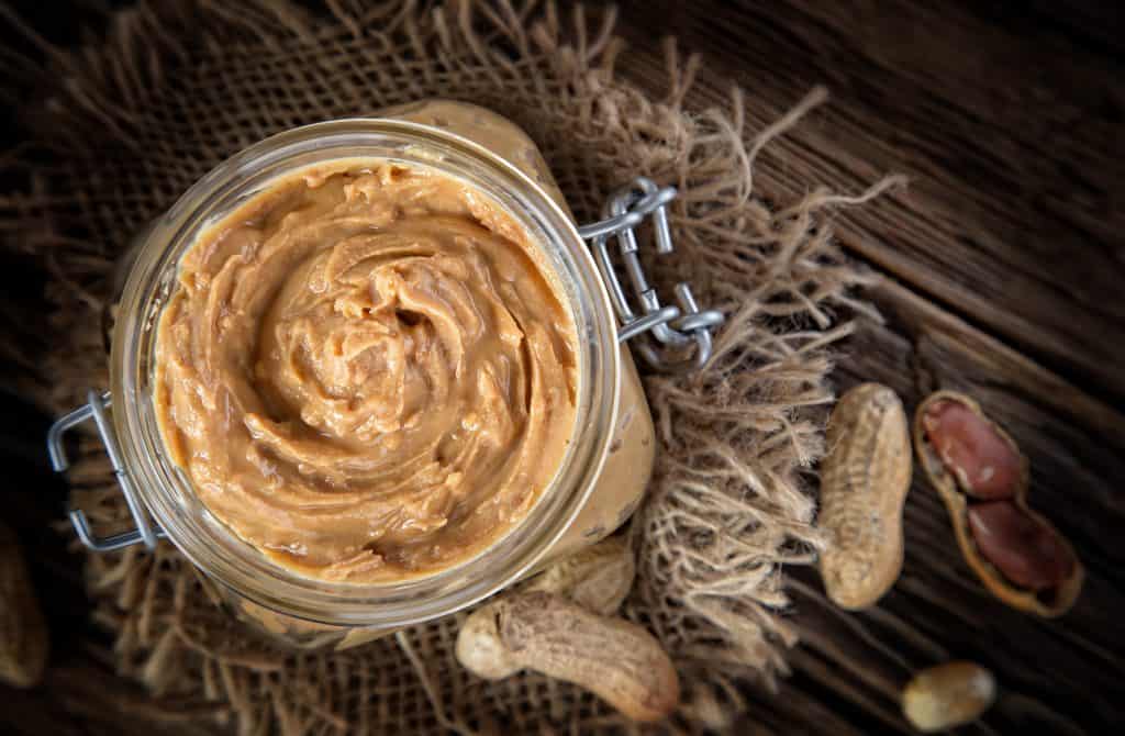 Peanut butter on wooden background, close-up.