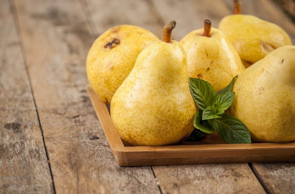 fresh pears on wooden tray