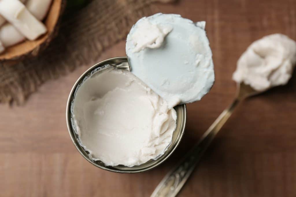 Coconut cream in opened tin on wooden table