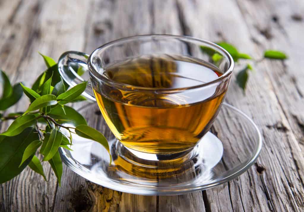 green tea in a clear cup on a wooden background