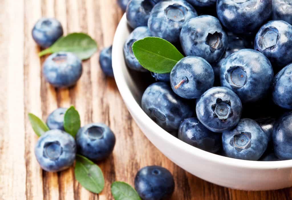 Blueberries in a bowl on a wooden table.