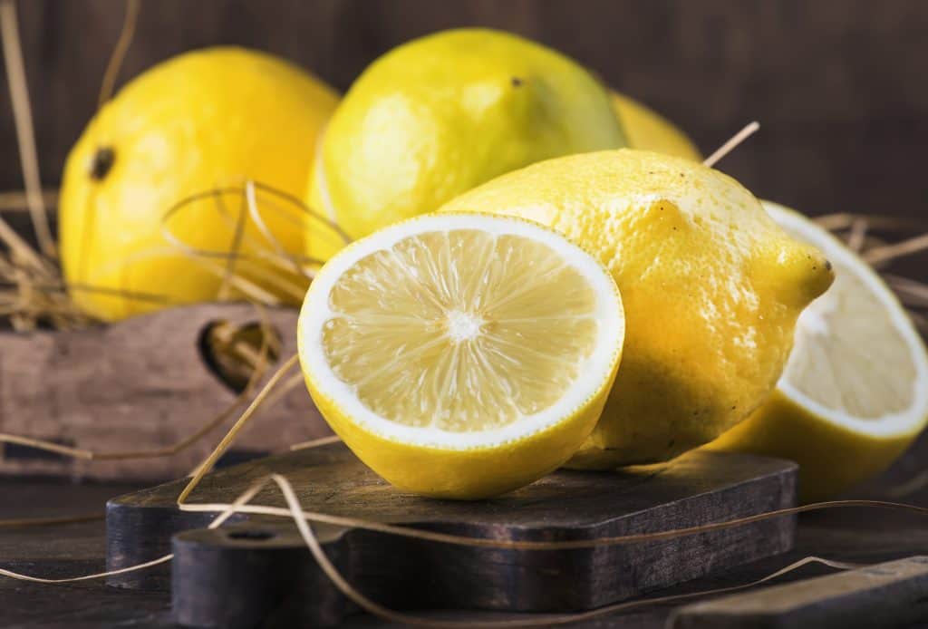 Juicy lemons on rustic kitchen table, copy space, selective focus