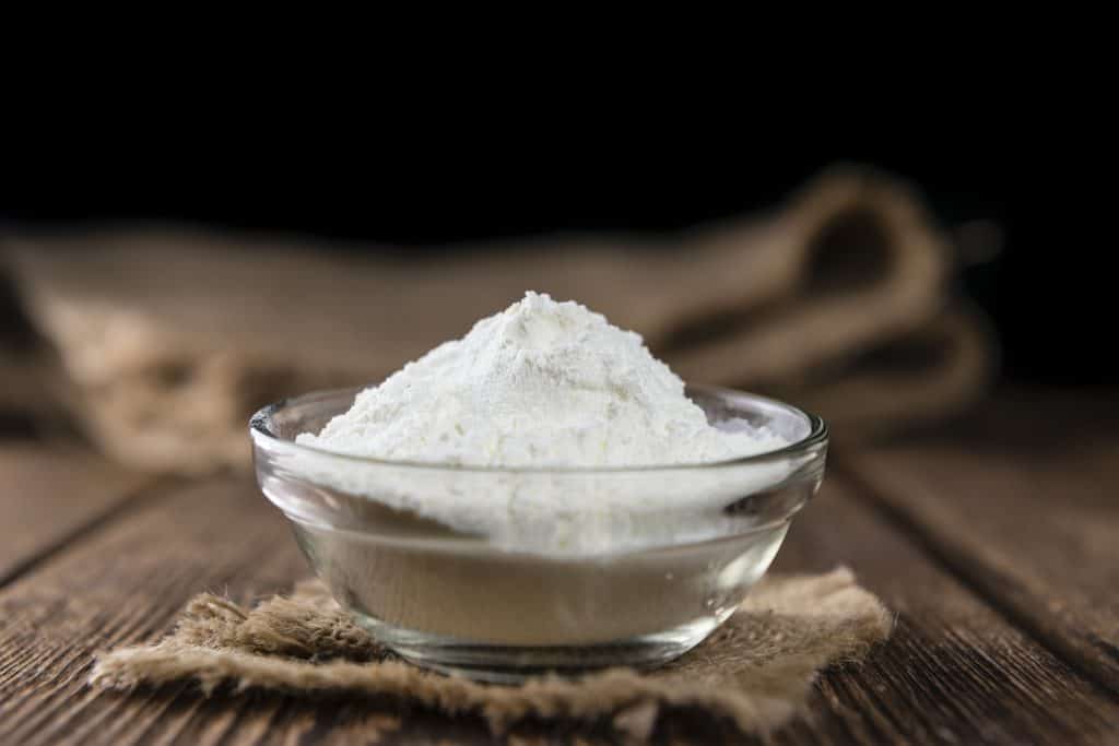 Heap of vanilla protein powder on an old wooden table