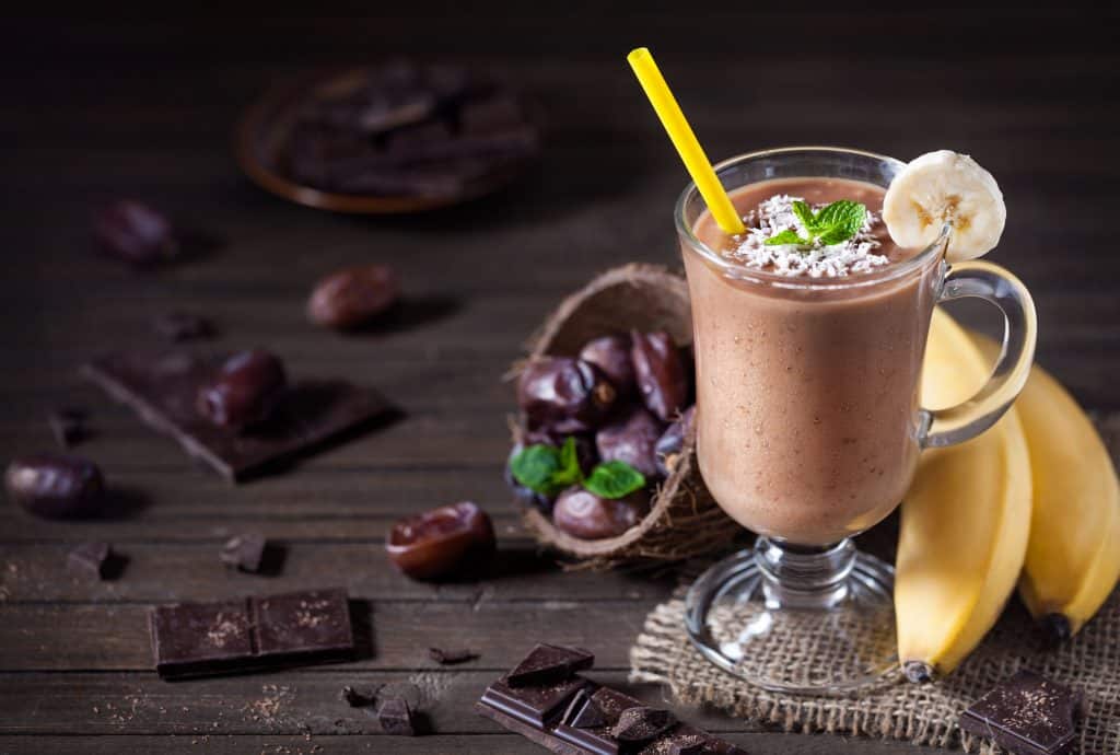 glass of chocolate banana smoothie with dark background