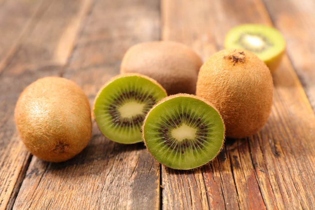 fresh kiwi on wooden board