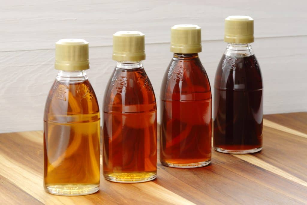 four different grades of maple syrup in small jars