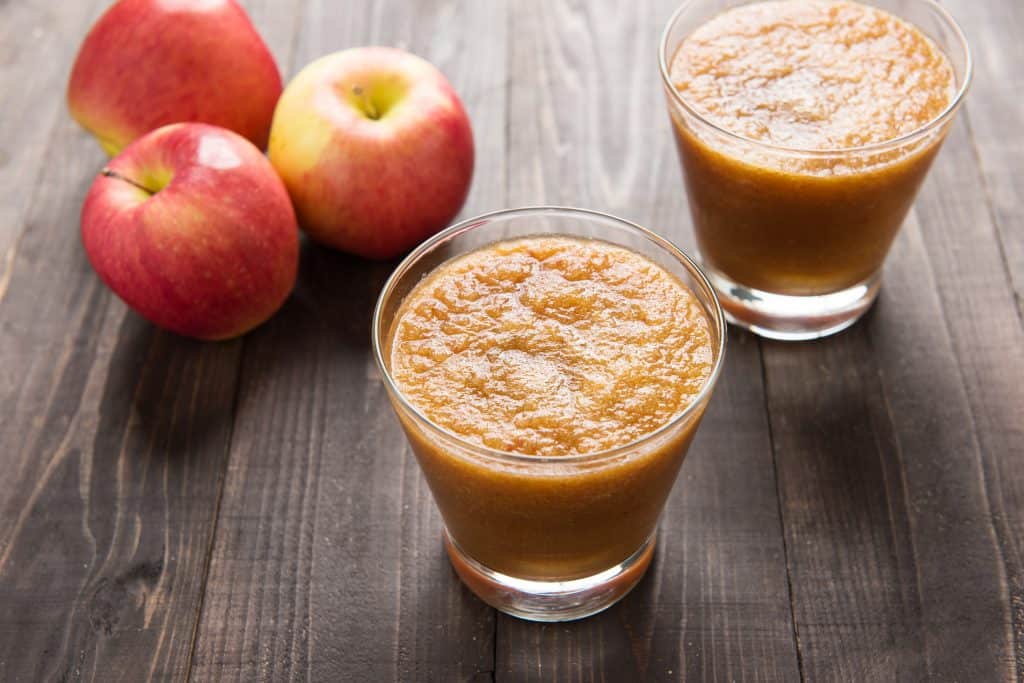 Red apple smoothies on wooden background