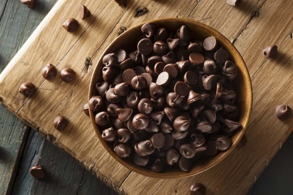 Organic Dark Chocolate Chips in a bowl on wooden background
