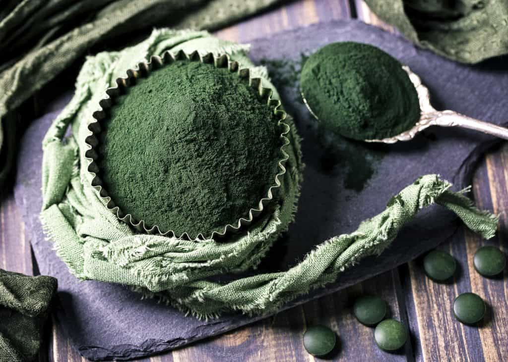 Spirulina powder on a wooden background