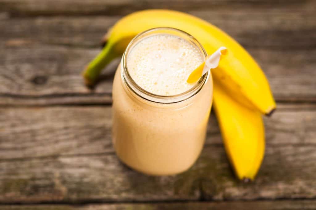 banana smoothie in glass jar on wooden table