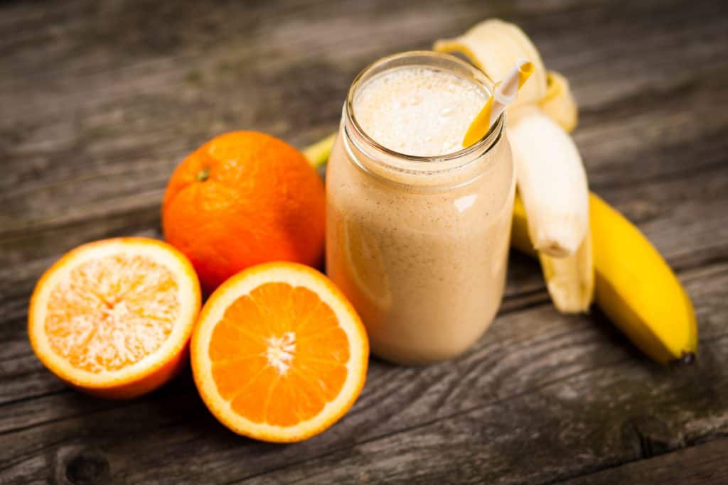 Banana orange smoothie on wooden table