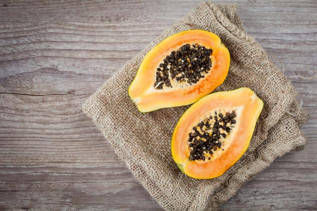 Sliced fresh papaya fruit on wooden background