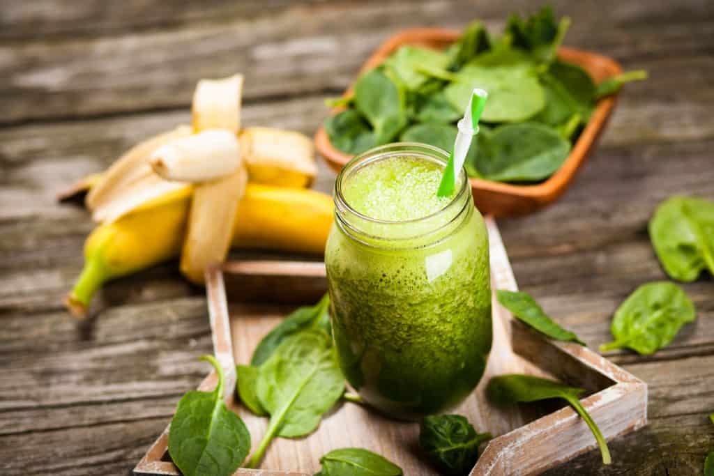 Fresh green spinach smoothie on wooden table