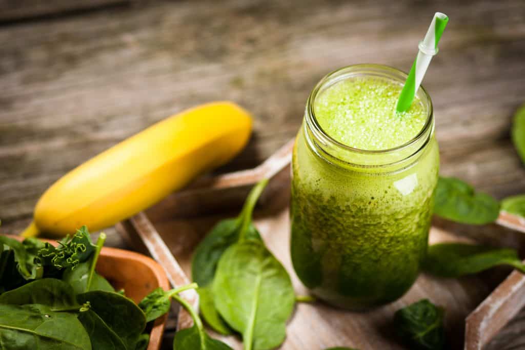 Fresh green spinach smoothie on wooden table