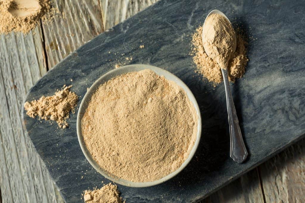 dry maca powder in bowl with spoon