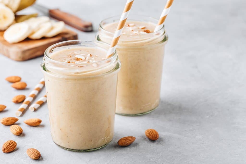 almond milk smoothies for weight loss in glasses with banana and almonds surrounding