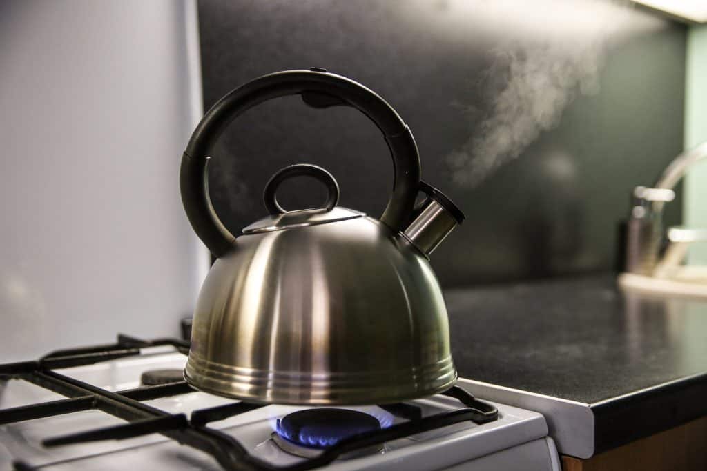 tea kettle coming to a boil on stovetop
