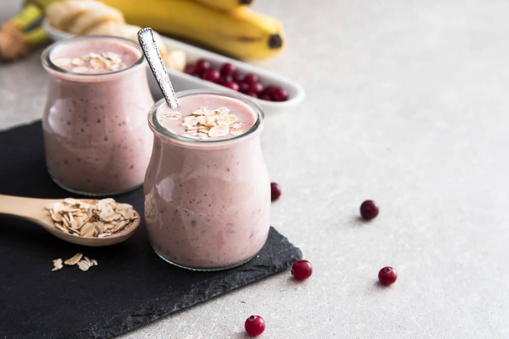 post workout smoothie for weight loss in glasses with cranberries, bananas and oats
