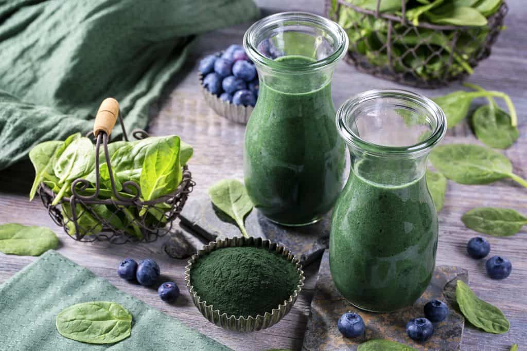 heavy metal detox smoothie in jars with ingredients surrounding