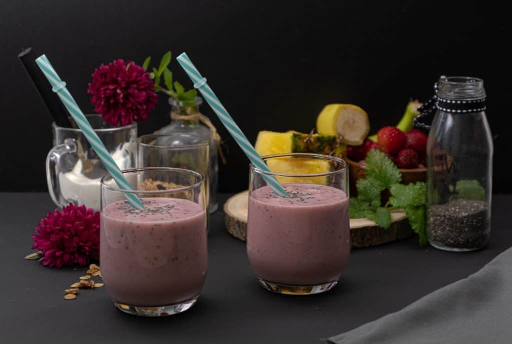 strawberry chia seed smoothies in glasses with ingredients in background