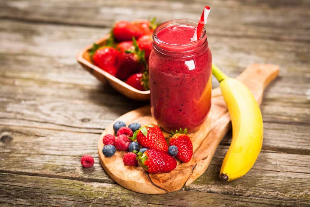 berry banana psyllium husk smoothie on wooden table