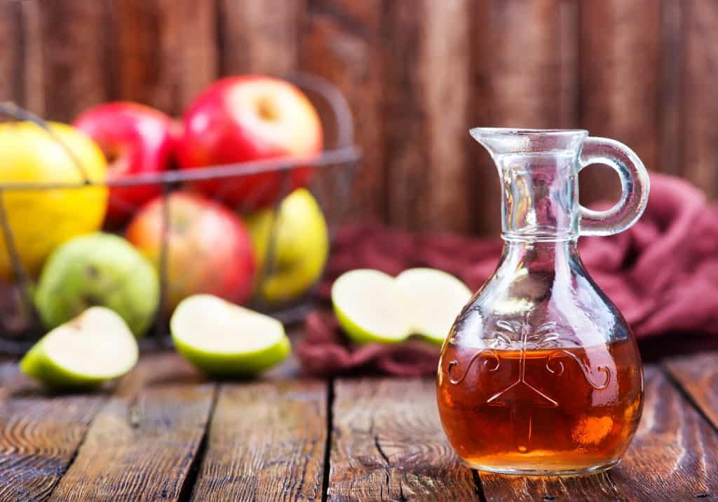 apple cider vinegar with apples in background