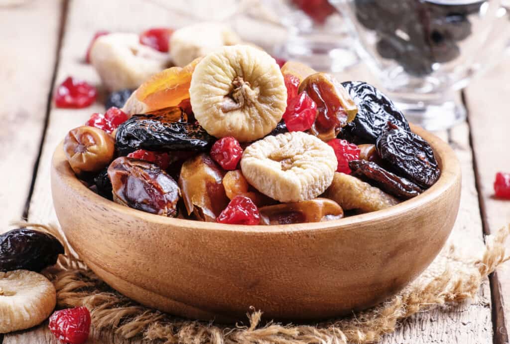bowl of assorted dried fruit on wooden table