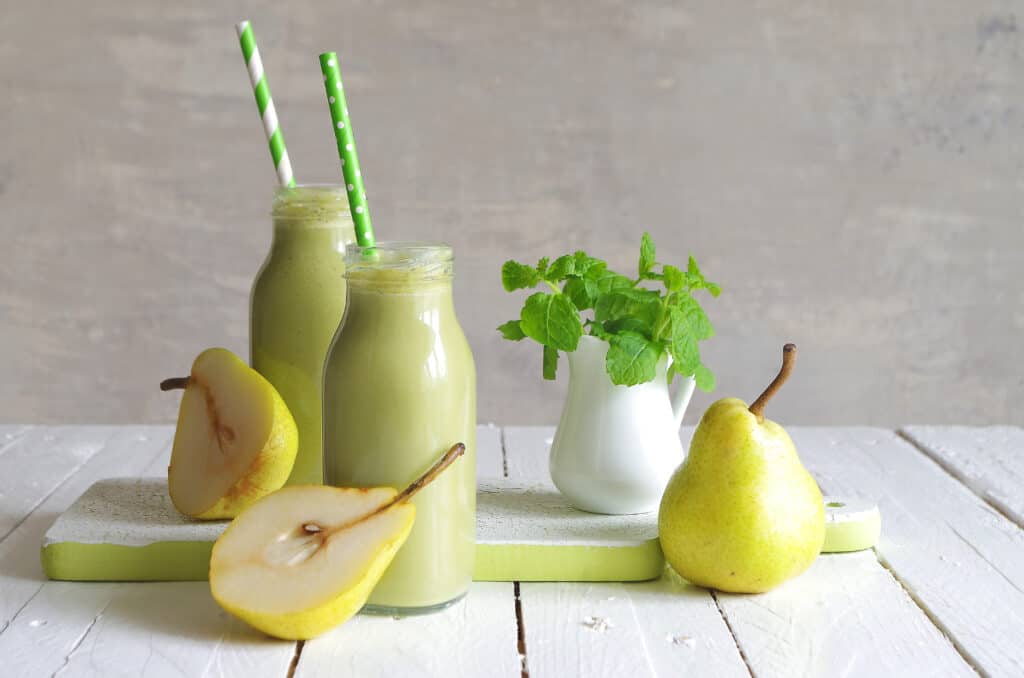 pear smoothie for weight loss in two jars with green straws and pears surrounding