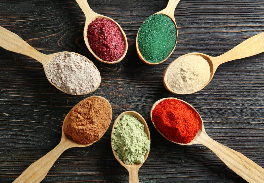 best powders for smoothies in spoons on wooden background