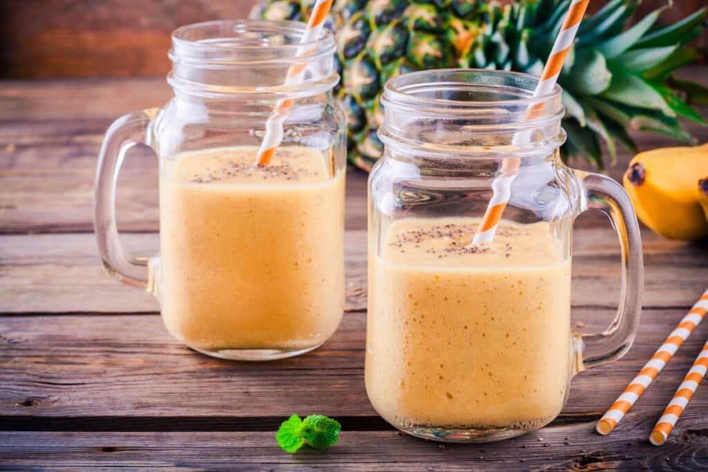 red bull smoothie with pineapple and banana in background